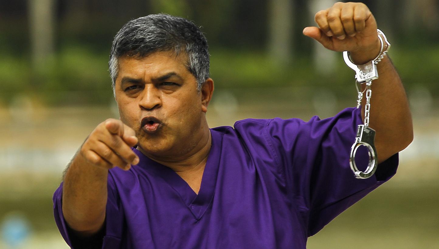 Malaysian political cartoonist Zulkiflee Anwar Haque, or 'Zunar', reacts with mock handcuffs during the launch of a satirical book in Petaling Jaya, near Kuala Lumpur, on Feb 14, 2015. -- PHOTO: EPA