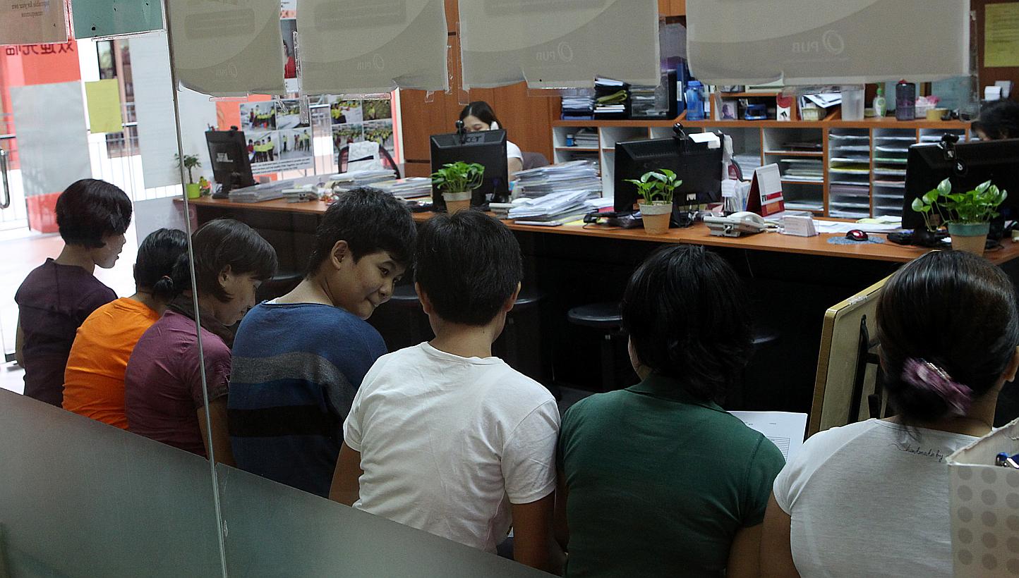 Indonesian and Fillipino maids at a maid agency in Singapore. Indonesia president Joko Widodo said the country will stop sending its woman to work as maids overseas to preserve its dignity. -- PHOTO: ST FILE