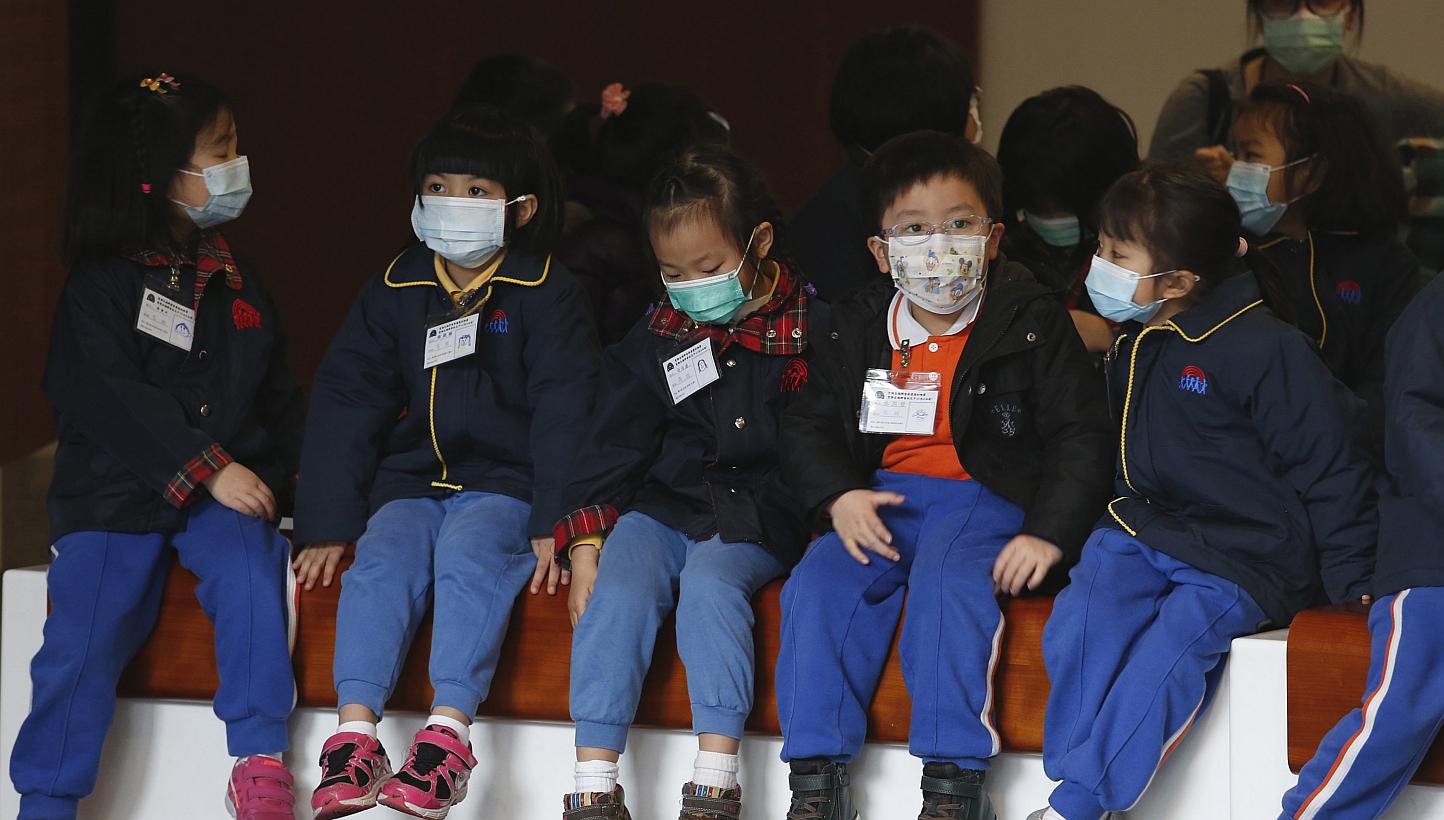 Children in masks visiting Hong Kong's Legislative Council last Friday. The flu death toll so far this year has hit 196, up from 133 early last year.