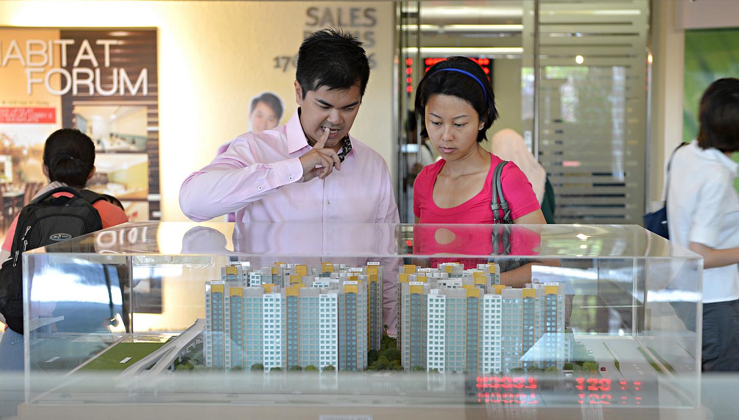 People looking at models of HDB flats. Analysts said a decreased BTO supply last year may have contributed to the dip in the number of applications. There were 22,455 BTO flats offered last year, down from 26,494 in 2013. -- PHOTO: ST FILE&nbsp;