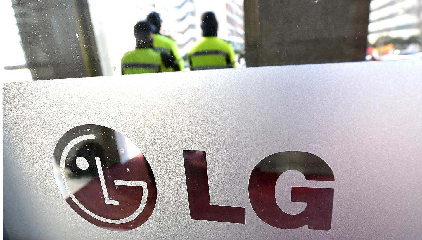 The logo of South Korea's LG Group is seen on a window as policemen stand guard at the company's headquarters in Seoul on Dec 26, 2014.&nbsp;South Korea’s LG Electronics, whose appliance chief has been indicted on a charge of purposely damaging Sam