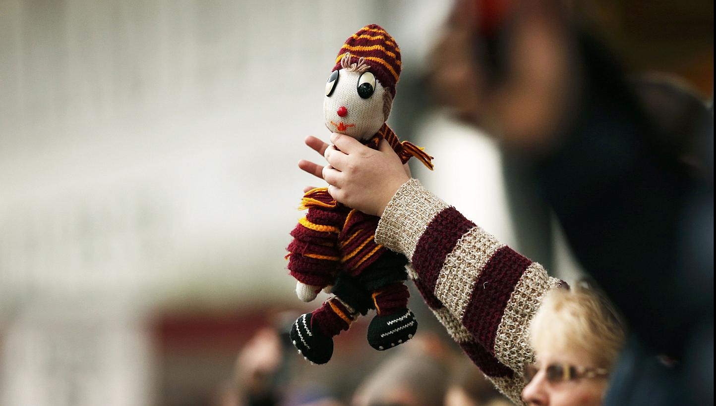 A Bradford City supporter holds a mascot during their FA Cup fifth round soccer match against Sunderland at Valley Parade in Bradford, northern England on Sunday. -- PHOTO: REUTERS