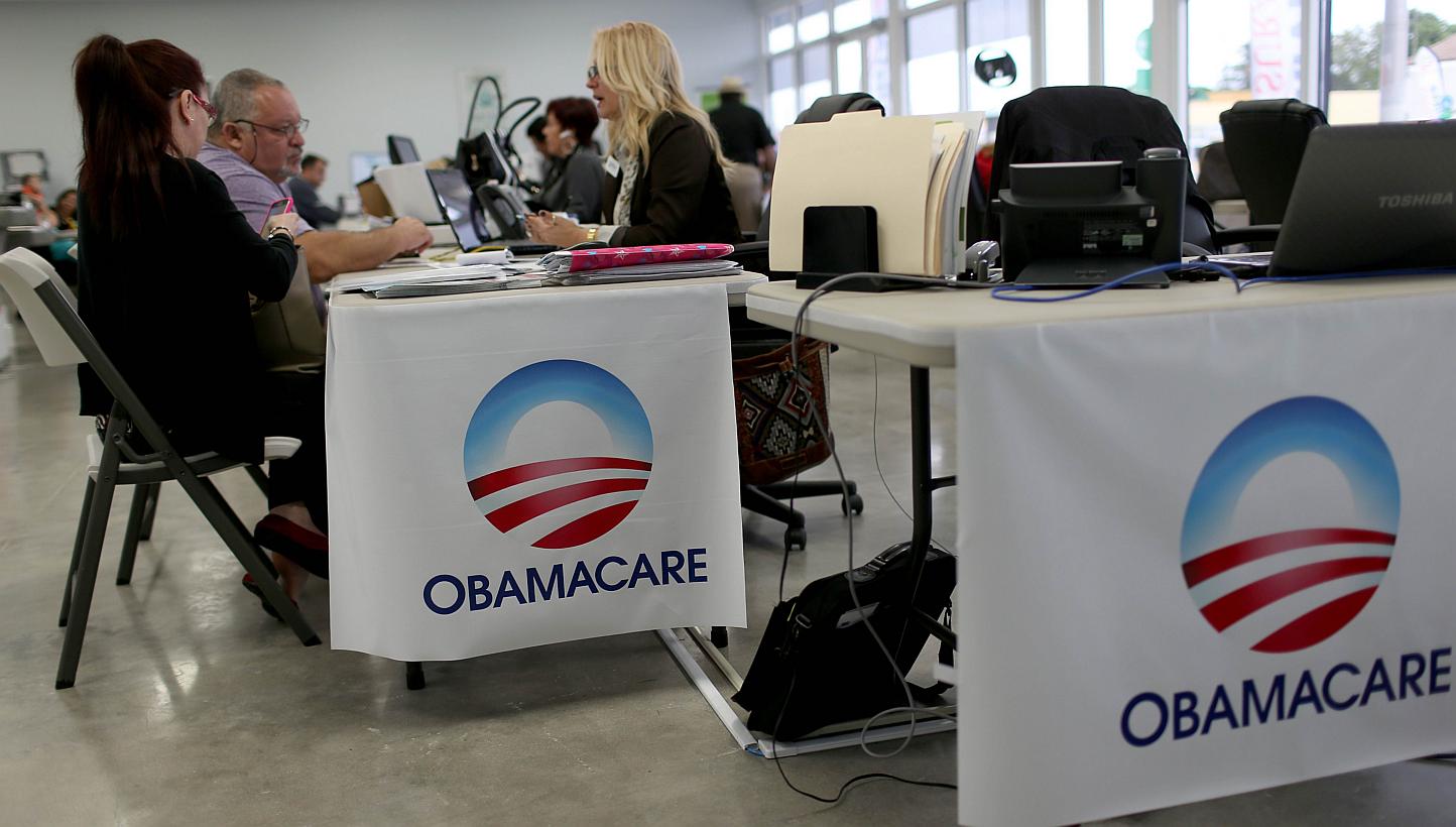 Aymara Marchante (left) and Wiktor Garcia sit with Maria Elena Santa Coloma, an insurance advisor with UniVista Insurance company, as they sign up for the Affordable Care Act, also known as Obamacare, before the February 15th deadline on Feb 5, 2015