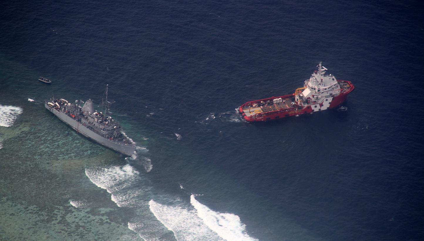 A Jan 24, 2013 photo shows an aerial view of the Malaysian tug boat Vos Apollo (right) preparing to remove fuel and other equipment from the US Navy ship USS Guardian (left), which ran aground in the vicinity of Tubbataha Reef, western Philippines. -