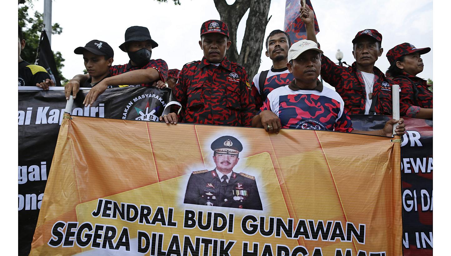 Supporters of Indonesian police chief nominee Budi Gunawan holding a banner with his picture outside the presidential palace in Jakarta, Indonesia on Feb 16, 2015,&nbsp;shortly after an Indonesian court cleared the three star general of being a graft