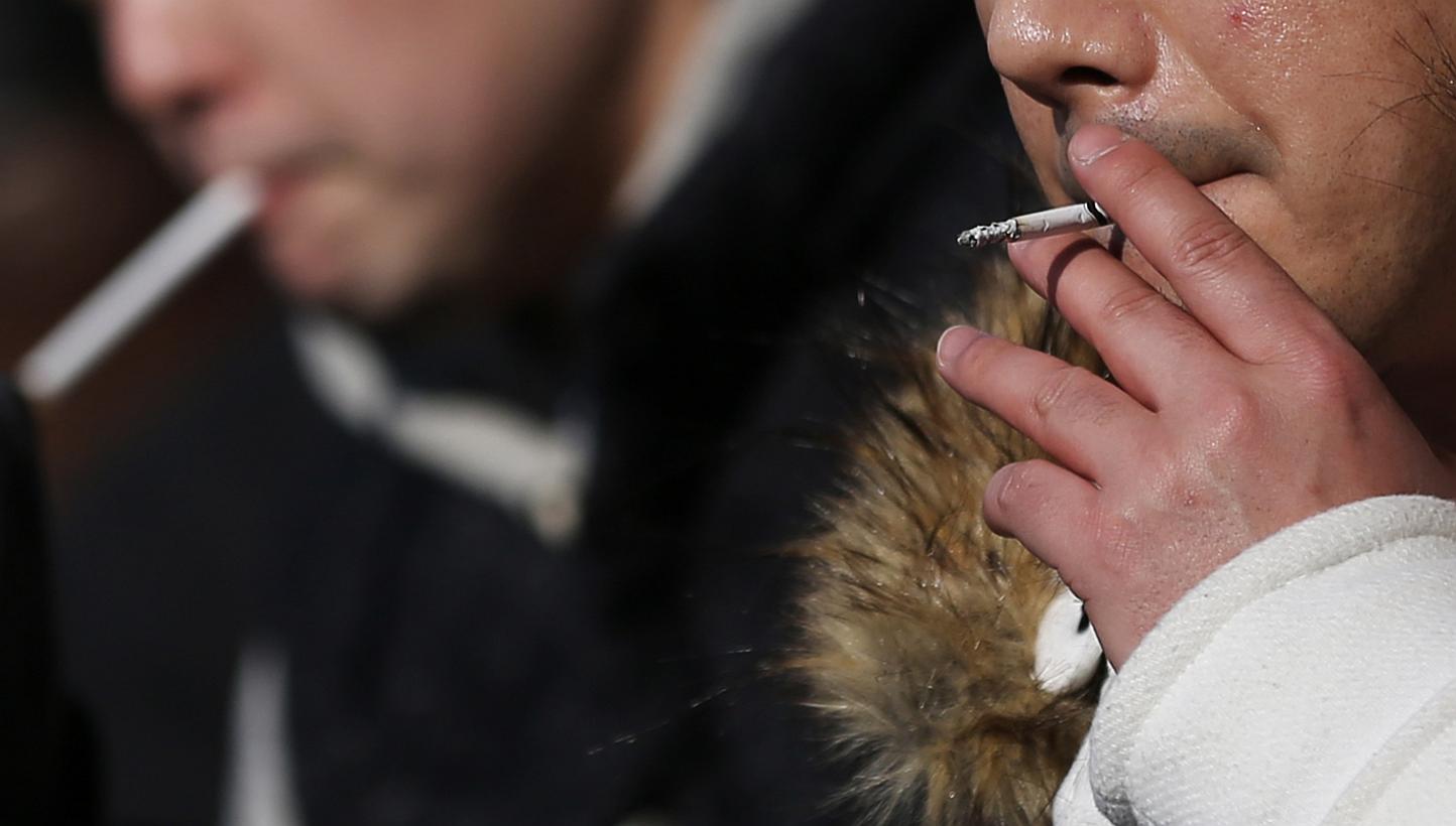 People smoke in a designated smoking area in Tokyo, Japan, early this month. -- PHOTO:&nbsp;BLOOMBERG