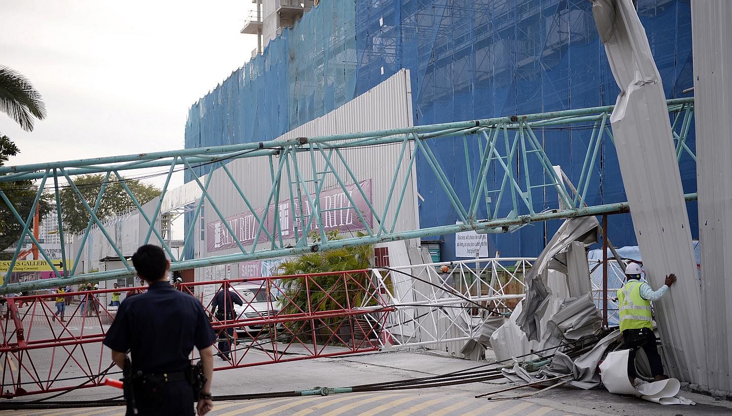 A crane from the construction site of upcoming condo Sant Ritz, in Potong Pasir, toppled over on Tuesday and crashed into the front yard of a semi-detached house across the road. -- ST PHOTO: MARK CHEONG