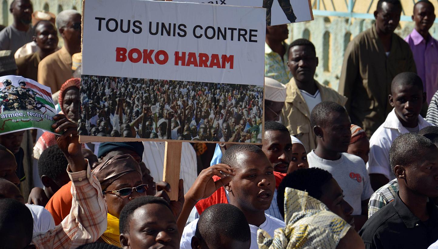 A person holds a sign reading "All united against Boko Haram" during a protest against deadly raids by Boko Haram on Feb 17, 2015 in Niamey. This week in another attack likely to be by the same group, a teenage girl blew herself up at a crowded bus s