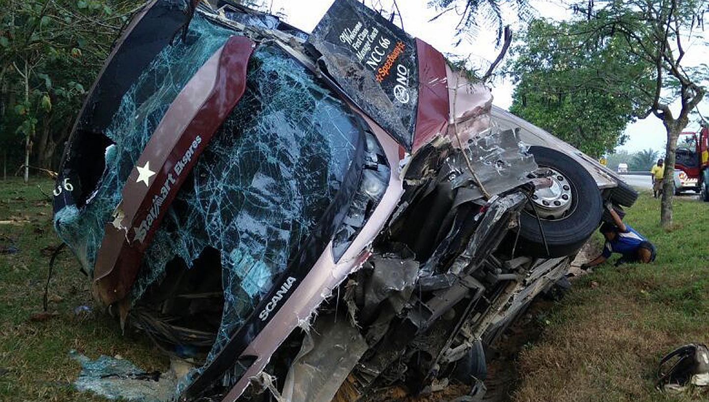 Twenty-seven passengers were left injured, three of them seriously, after an express bus rammed into a road divider and fell into a drain on Tuesday. -- PHOTO: SIN CHEW DAILY
