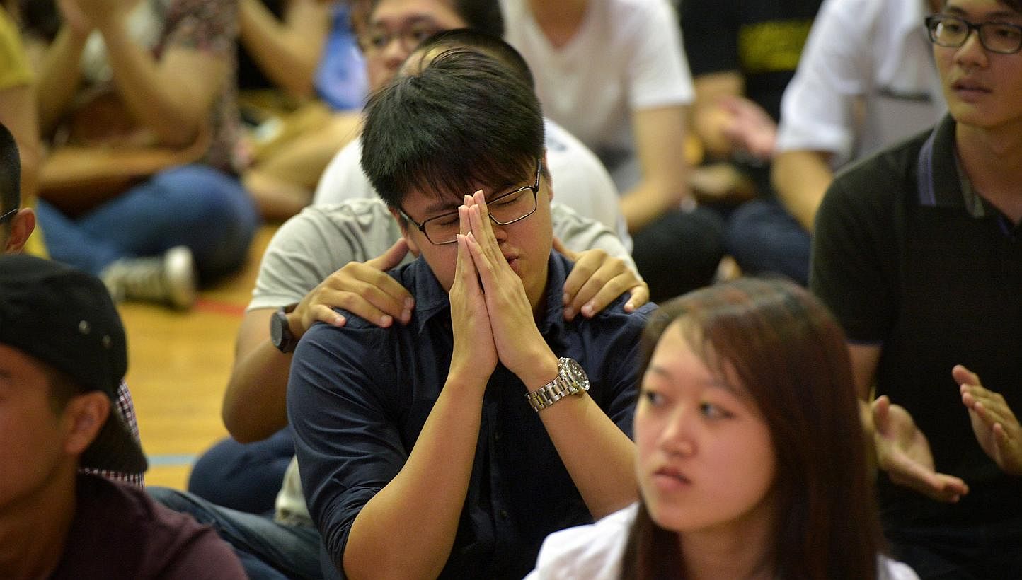 A student clasps his hands while others wait in anxiety during the 2013 GCE A' level results at Pioneer Junior College on March 3, 2014.&nbsp;The 2014 GCE A-Level Examination results will be released on March 2, 2015. -- ST PHOTO:&nbsp;KUA CHEE SIONG