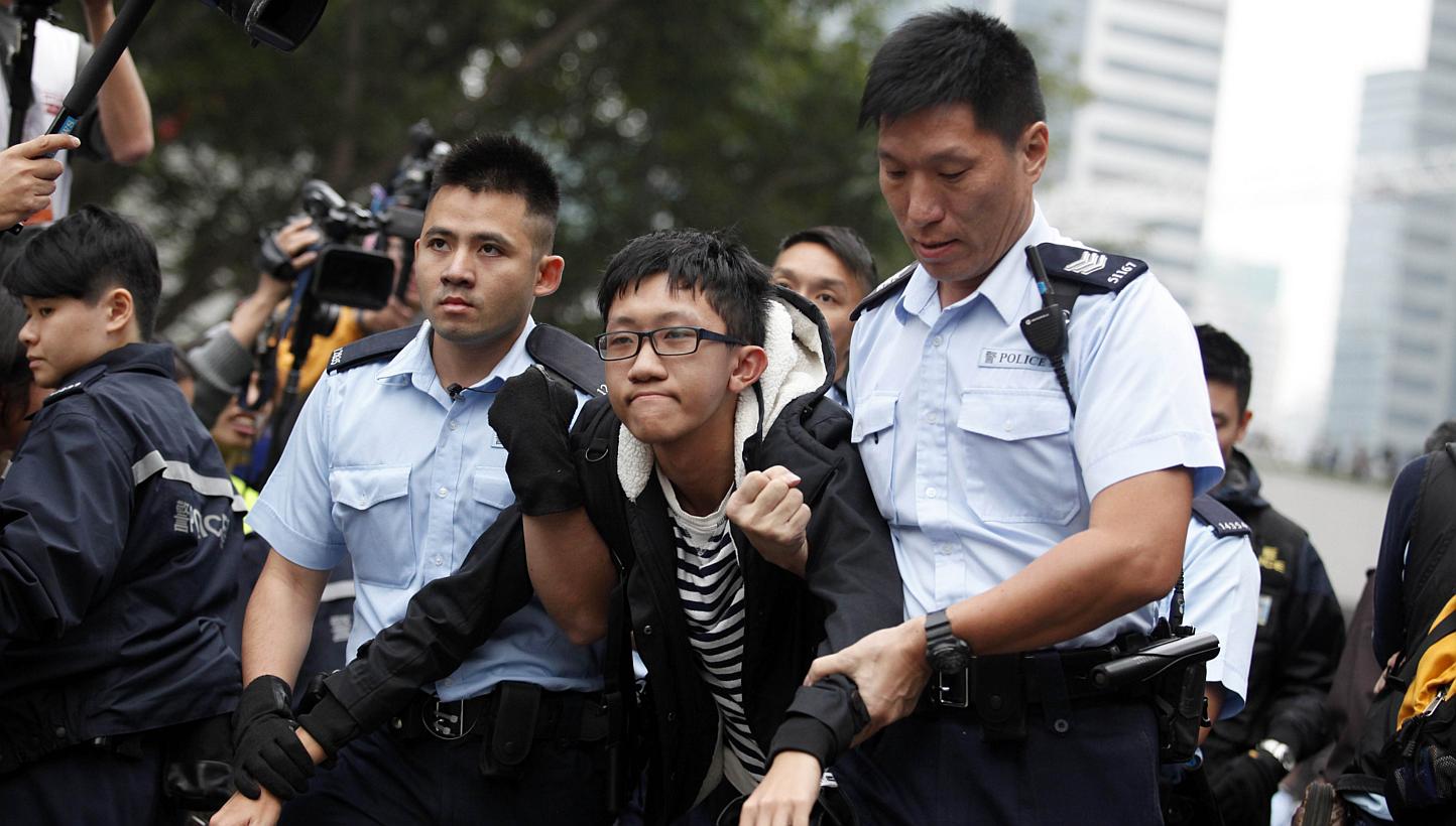 Hong Kong police detain a pro-democracy demonstrator (centre) as police clear the main protest site in the Admiralty district in Hong Kong on Dec 11, 2014. Asia's richest man, Li Ka Shing, said on Thursday, Feb 26, 2015,&nbsp;Hong Kong people would b