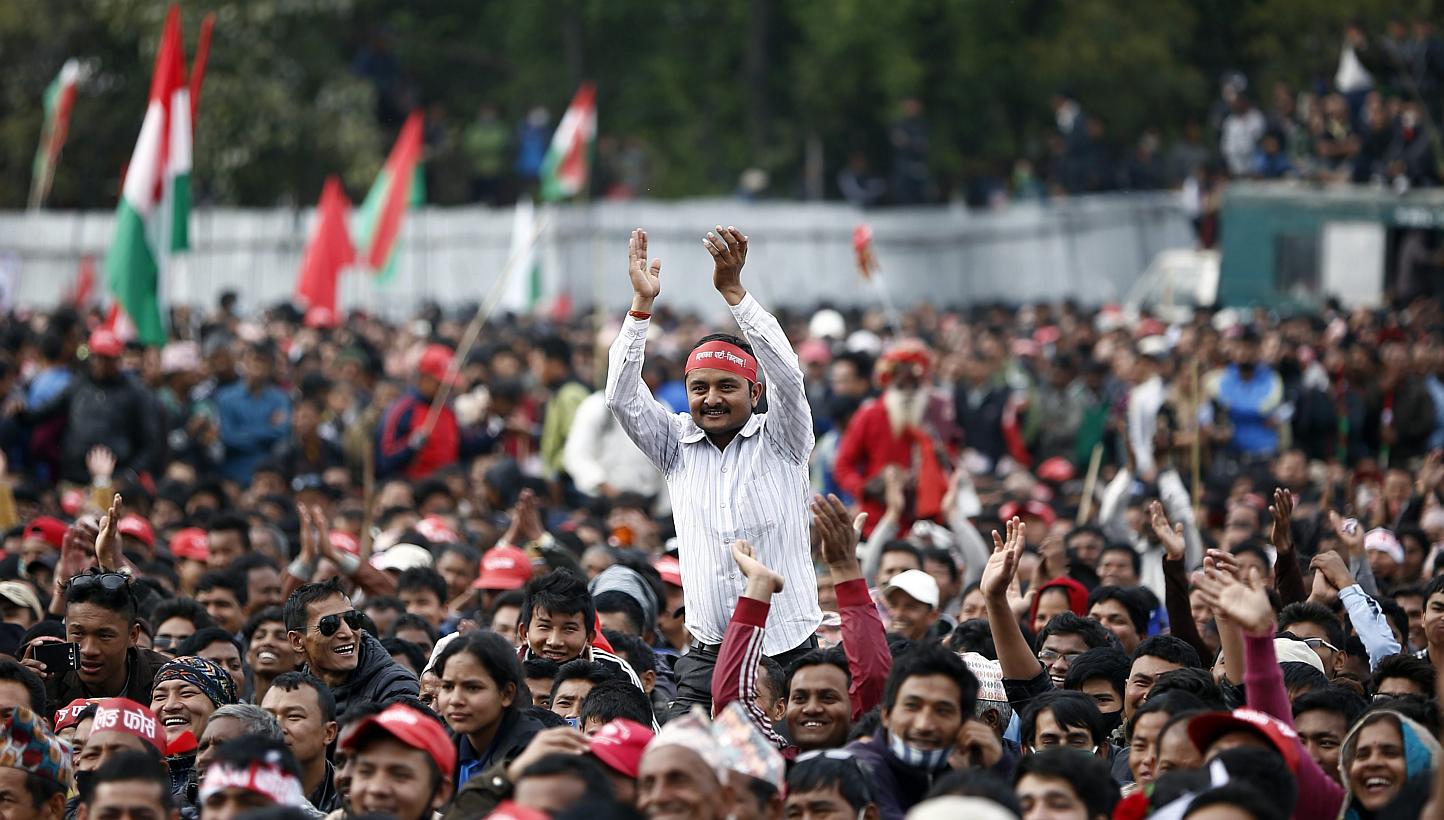 An activist rises above the crowd to clap during an anti-government mass meeting in Kathmandu, Nepal on Feb 28, 2015. Protesters and police clashed in Kathmandu on Saturday at a demonstration by some 30,000 people led by the Maoist oppositi