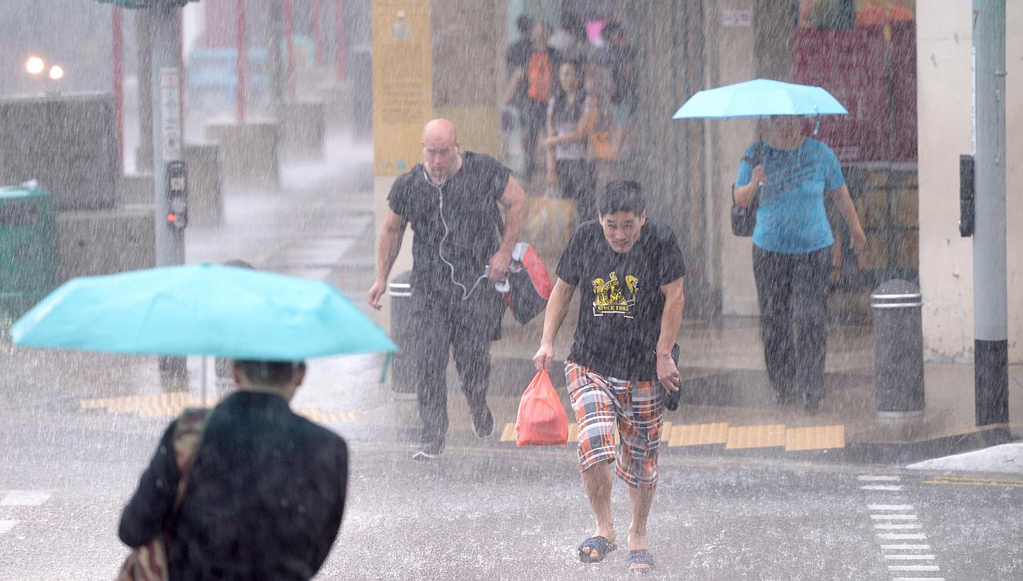 Pedestrians crossing the road at a pedestrian crossing at Upper Cross Street during a heavy downpour on Jan 6, 2015.&nbsp;Moderate to heavy thundery showers are expected over southern and western Singapore on Monday, announced NEA. -- ST PHOTO:&nbsp;
