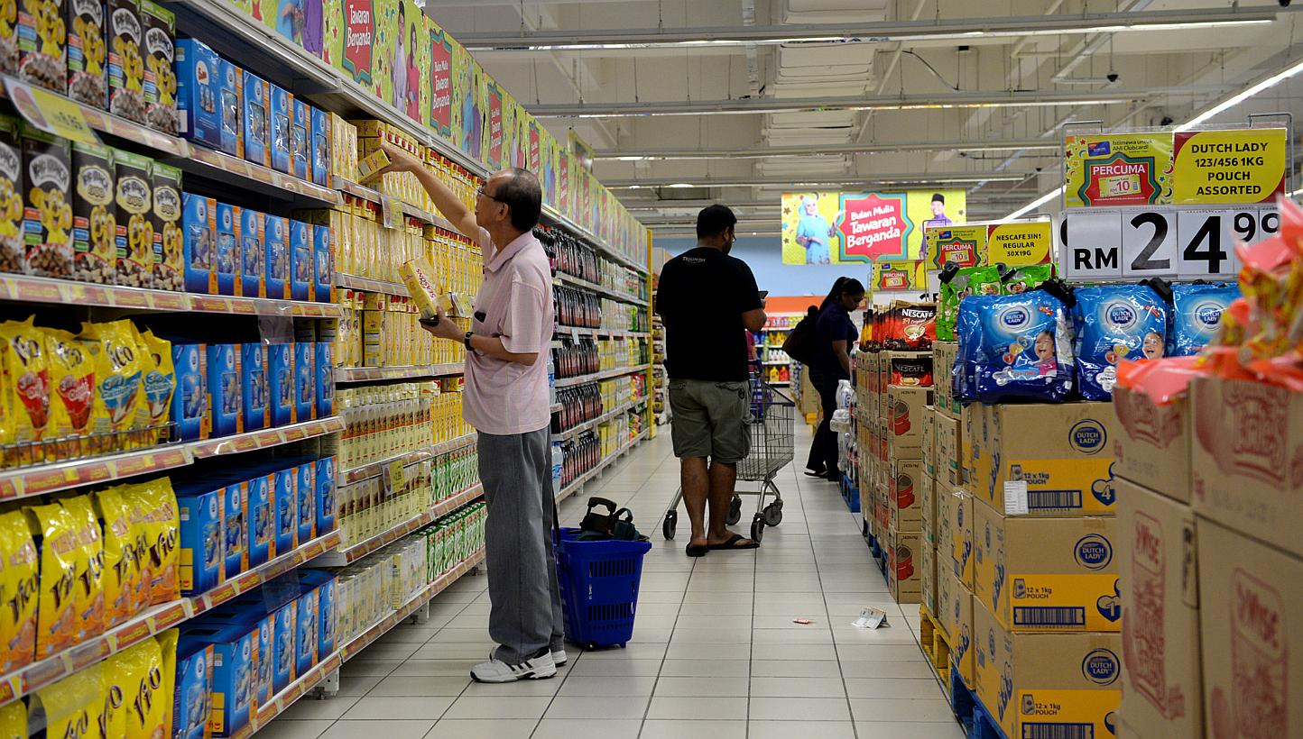 People buying groceries at Tesco in Johor Bahru’s KSL City. Major supermarkets in Malaysia will be slashing prices up to 70 per cent for more than 82,000 products as part of a new national price reduction campaign. -- PHOTO: ST FILE