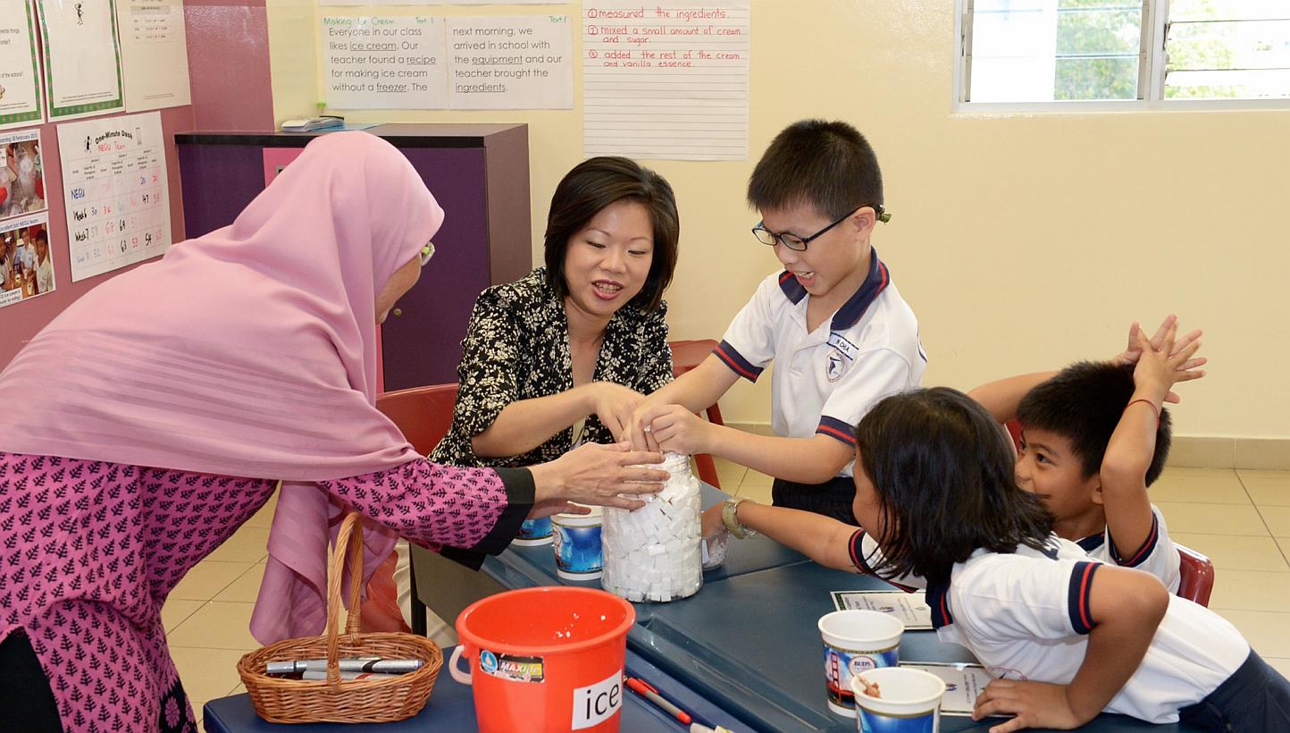 Ms Sim Ann (centre), Minister of State for Education and Communications and Information, looking on as Allied Educator Mdm Tutek gives a lesson to Primary 4 children from Tampines Primary School. -- ST PHOTO: DESMOND WEE 