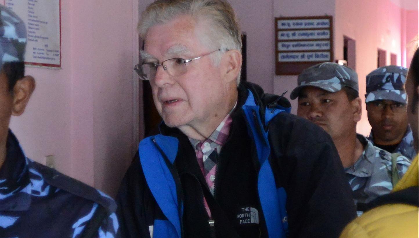 Canadian national Ernest Fenwick MacIntosh, convicted of sexually abusing a Nepalese child on Sunday is escorted by police for his appearance at the District Court in Lalitpur in a suburb of Kathmandu. -- PHOTO: AFP 
