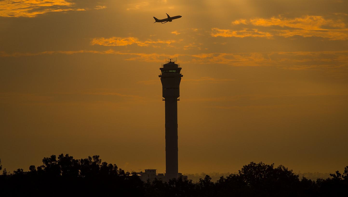 A plane flying past a control tower at Kuala Lumpur International Airport (KLIA). -- PHOTO: AFP