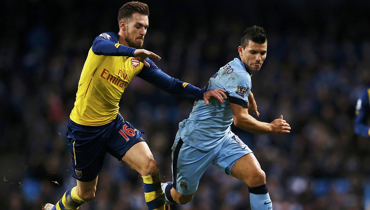 Arsenal's Aaron Ramsey (left) challenges Manchester City's Sergio Aguero during their English Premier League soccer match at the Etihad stadium in Manchester, northern England Jan 18, 2015. -- PHOTO: REUTERS