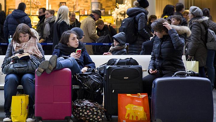 Passengers sit and wait at the Eurostar train terminal at St Pancras International station in London on Monday, after a fatality on the line in Kent. -- PHOTO: AFP