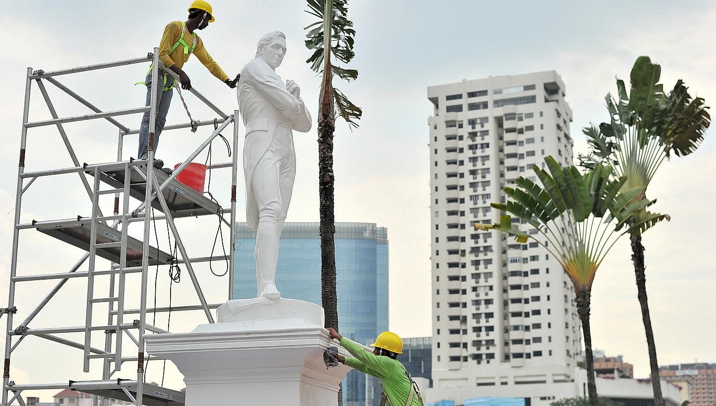 The statue of Sir Stamford Raffles being cleaned in 2014. Barricades and hoardings will soon be erected around several statues and landmarks along the Singapore River, to protect them from construction works. -- PHOTO: ST FILE&nbsp;