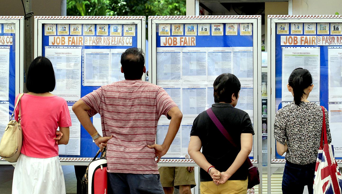 Visitors looking at the job listings displayed on boards at a job recruitment drive on May 3, 2014. -- PHOTO: ST FILE