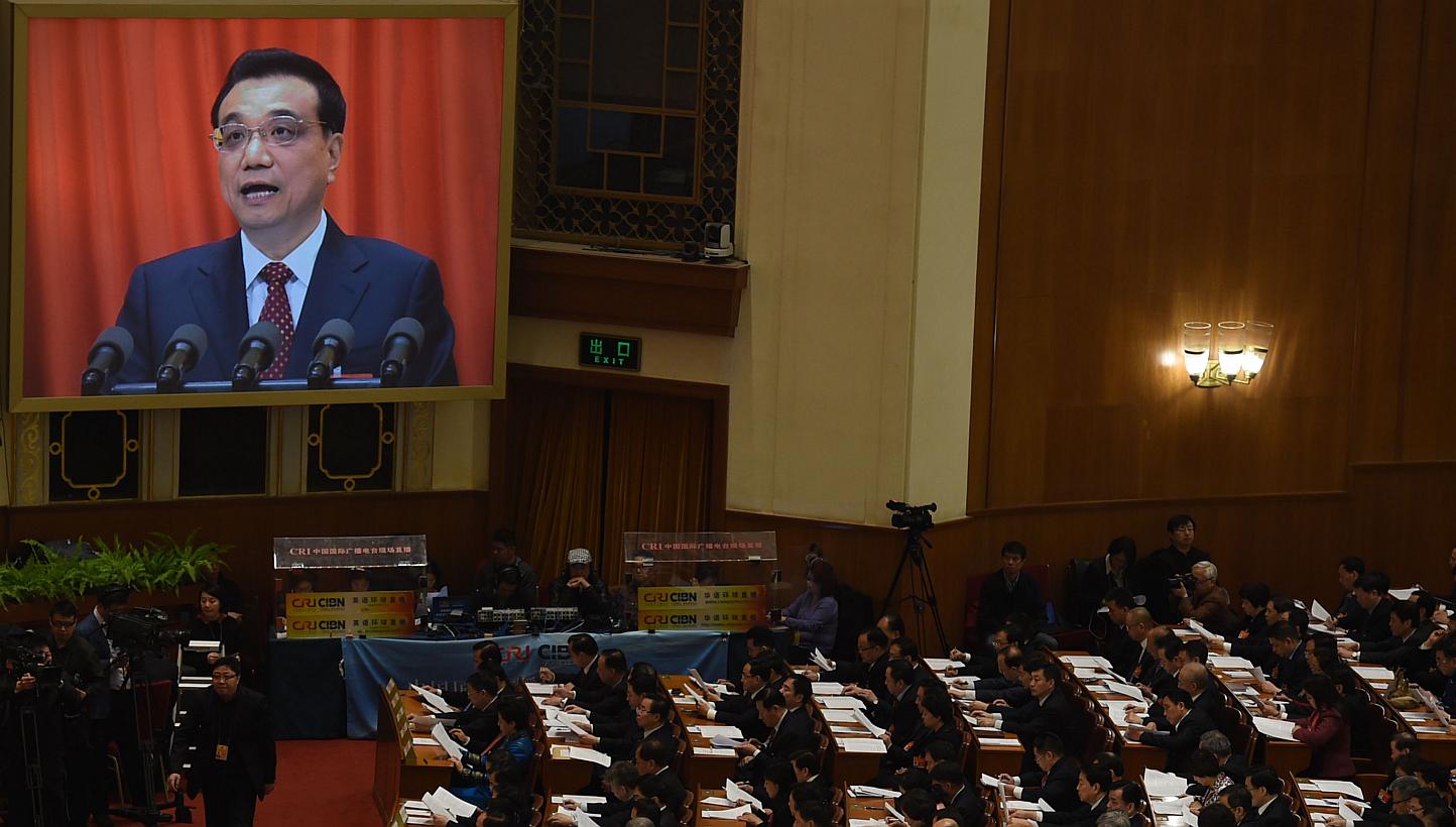Delegates listening as Chinese premier Li Keqiang (on screen) delivers his work report during the 12th National People's Congress in Beijing on March 5, 2015. -- PHOTO: AFP