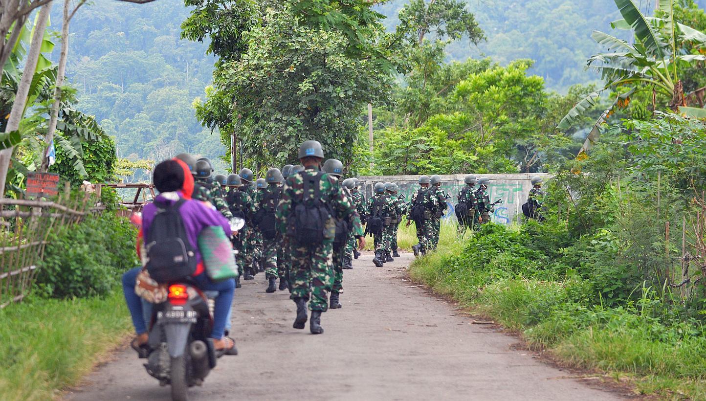 Indonesian military troops marching near Nusakambangan island (in the background) on March 5, 2015, where Australian death row inmates Andrew Chan and Myuran Sukumaran were transferred from Kerobokan prison in Bali. -- PHOTO: AFP