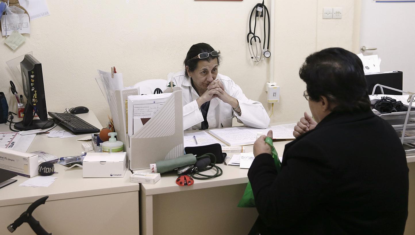 A doctor listening to a patient inside a medical centre of the Greek delegation of the Doctors of the World in Perama, near Athens, on March 5, 2015. -- PHOTO: RETUERS&nbsp;