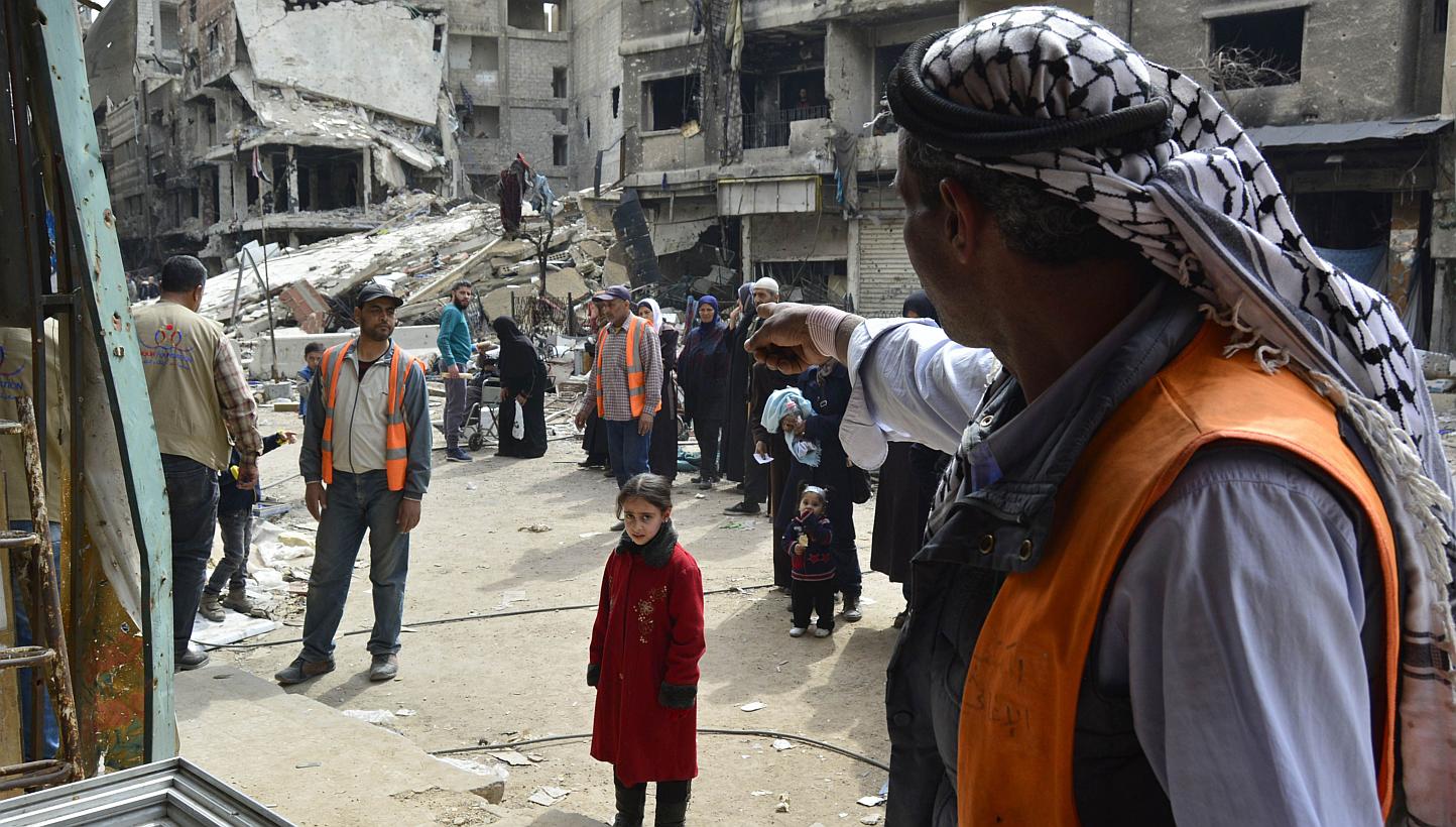 Palestinian refugees queue up to receive aid parcels from a local organisation at the Yarmuk refugee camp, south of the Syrian capital Damascus, on March 11, 2015.&nbsp;Clashes between armed factions and the Islamic State in Iraq and Syria group rage