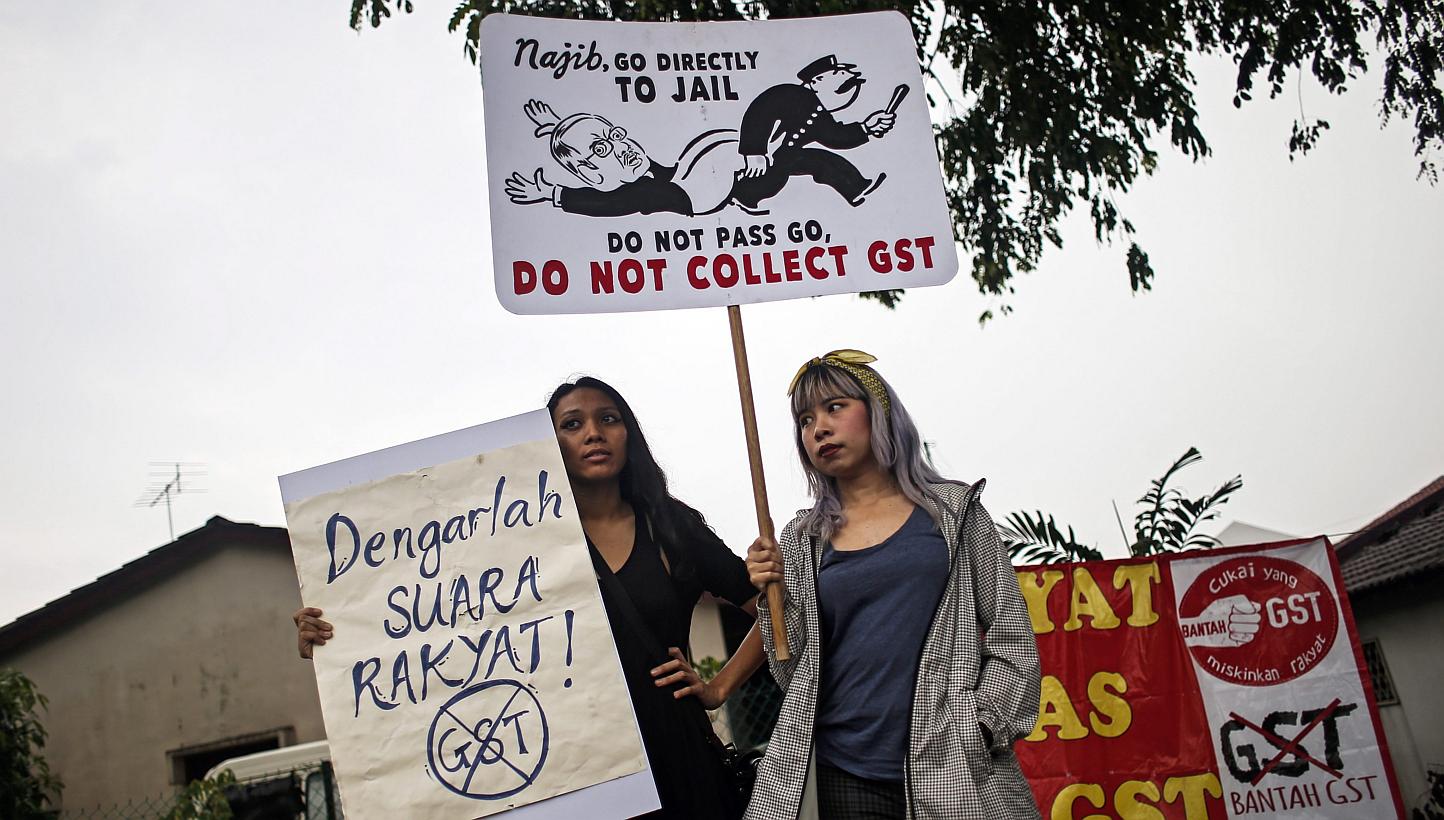 Malaysian protestors hold a poster reading 'No GST' as they protest outside custom office at Kelana Jaya,suburb of the capital Kuala Lumpur, Malaysia on March 23, 2015. More than 100 protestors from NGO's and political parties staged a protest outsid