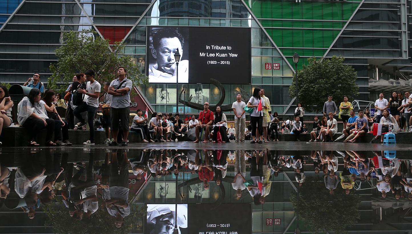 The crowd at Singapore's Raffles Place watching the live telecast of Mr Lee Kuan Yew's funeral service on March 29, 2015. -- PHOTO: ST FILE