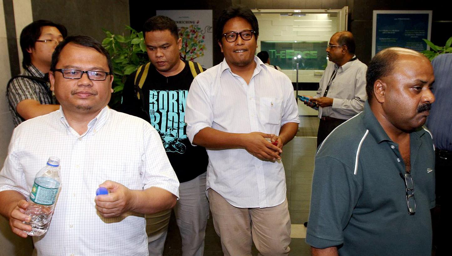 (Foreground, from left) The Malaysian Insider's features editor Zulkifli Sulong, Bahasa news editor Amin Shah Iskandar and managing editor Lionel Morais being led out of their office in Mutiara Damansara, Petaling Jaya, on Monday. The three of them w