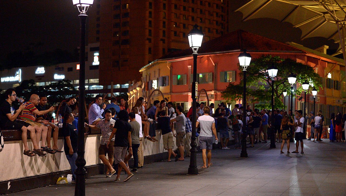At least 200 people were seen on Read Bridge at Clarke Quay after midnight and drinking even though the new Liquor Control (Supply and Consumption) Act bans drinking in all public places from 10.30pm to 7am. -- ST PHOTO: DESMOND WEE'