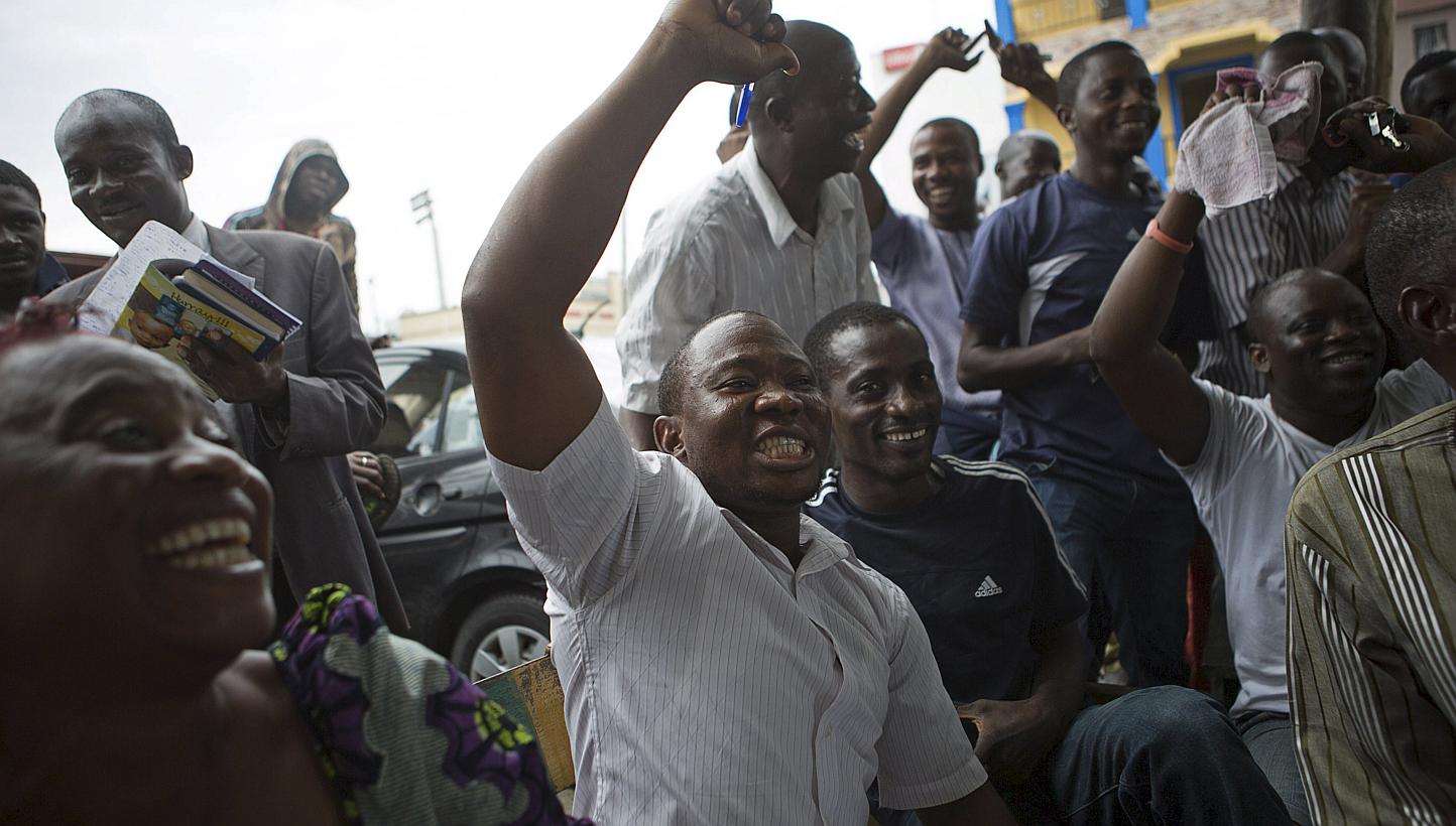 Supporters of presidential candidate Muhammadu Buhari cheer as they watch news coverage of election results favourable to them on a street in Lagos, March 31, 2015. -- PHOTO: REUTERS
