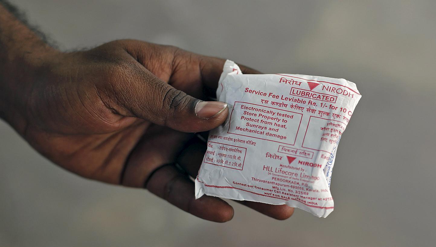 A man shows a packet of government-supplied 'Nirodh' condoms after collecting it from a distribution centre at a hospital in New Delhi on April 1, 2015. -- PHOTO: REUTERS