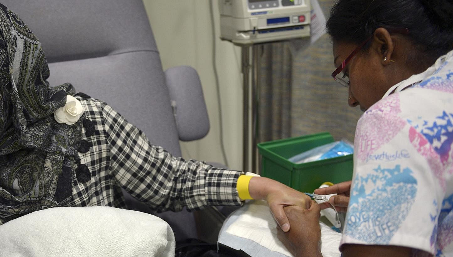 A nurse inserting a needle into a patient's hand for chemotherapy treatment at the National Cancer Centre Singapore (NCCS). A study by the Lien&nbsp;Centre for Palliative Care and collaborators from NCCS has found that late-stage cancer patients woul