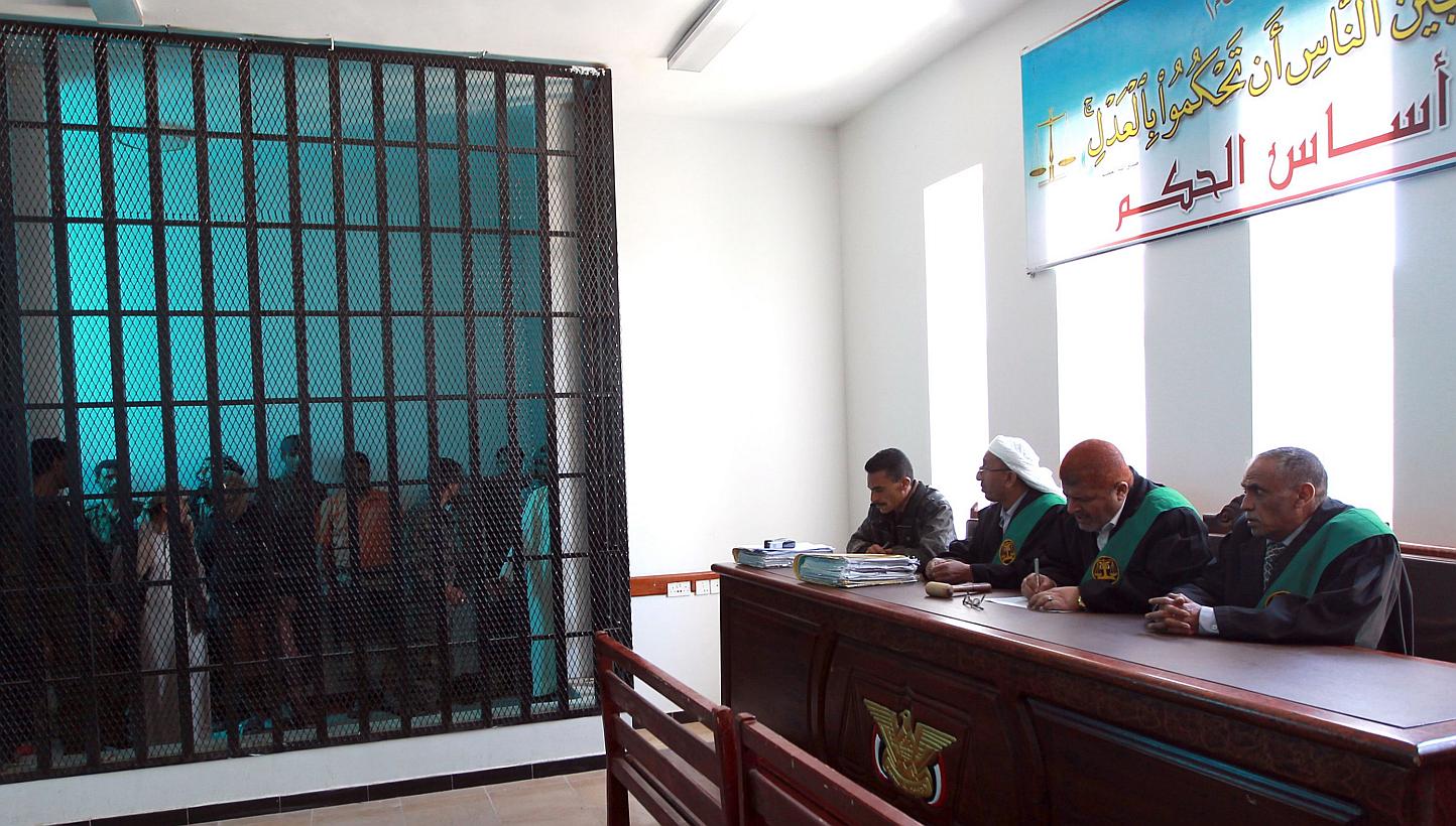 Suspected Al-Qaeda militants stand behind bars during a hearing at the appeals court in the Yemeni capital Sanaa on Feb 10, 2015.&nbsp;Al-Qaeda militants stormed a prison in south-eastern Yemen on Thursday, freeing several hundred inmates including o