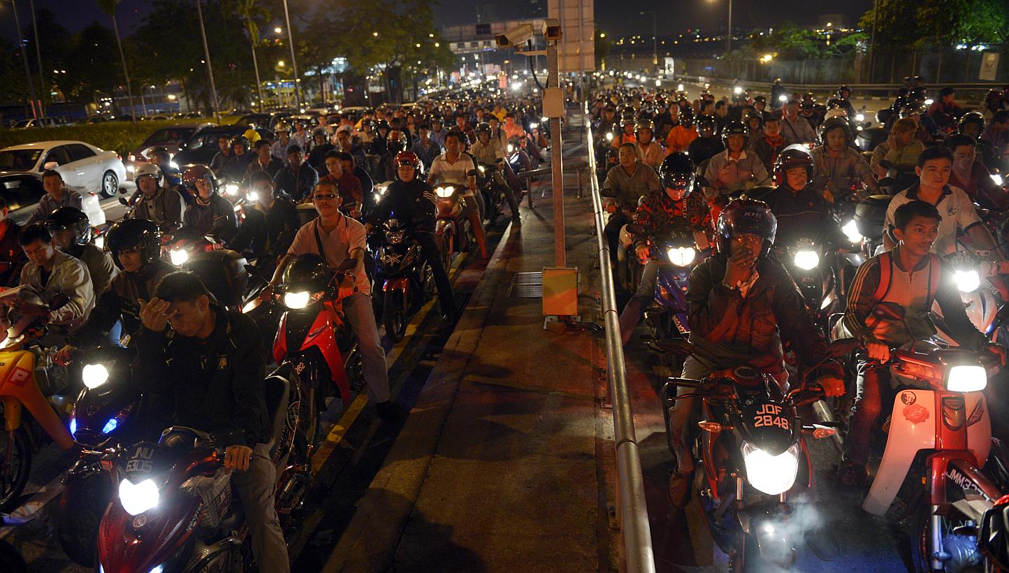 Long queues even at 5.30am as motorcyclists bound for Singapore wait for their turn at the Woodlands checkpoint. Under the tender for the two land checkpoints, at least 110 motorcycles should be cleared per hour per lane when all lanes are in operati