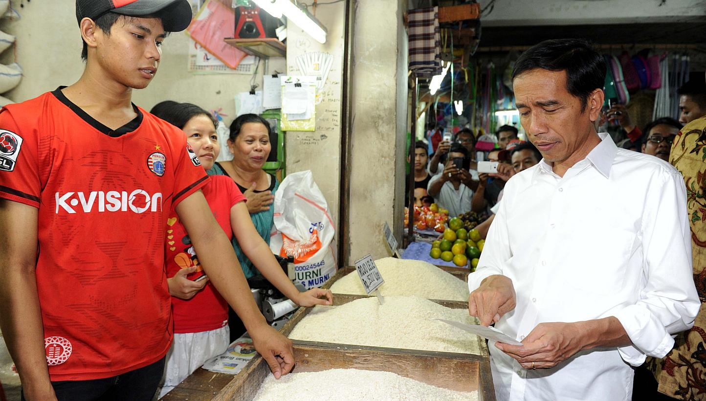 Mr Joko Widodo (right) visiting a traditional food market in Jakarta. With a slowing economy, the Indonesian President needs to attract investments. But to do that, he must address bureaucratic bottlenecks, reform the civil service, broaden the inves