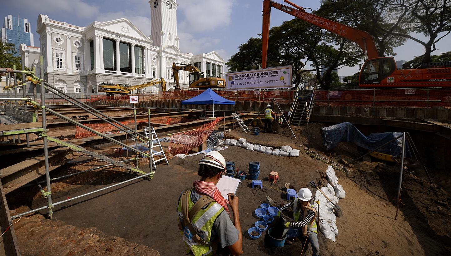 Institute of Southeast Asian Studies (Iseas) archaeology unit research officer Aaron Kao (centre) keeping a record as volunteer Natalie Khoo checks for relics at the excavation site in front of Victoria Theatre and Victoria Concert Hall on Feb 13, 20