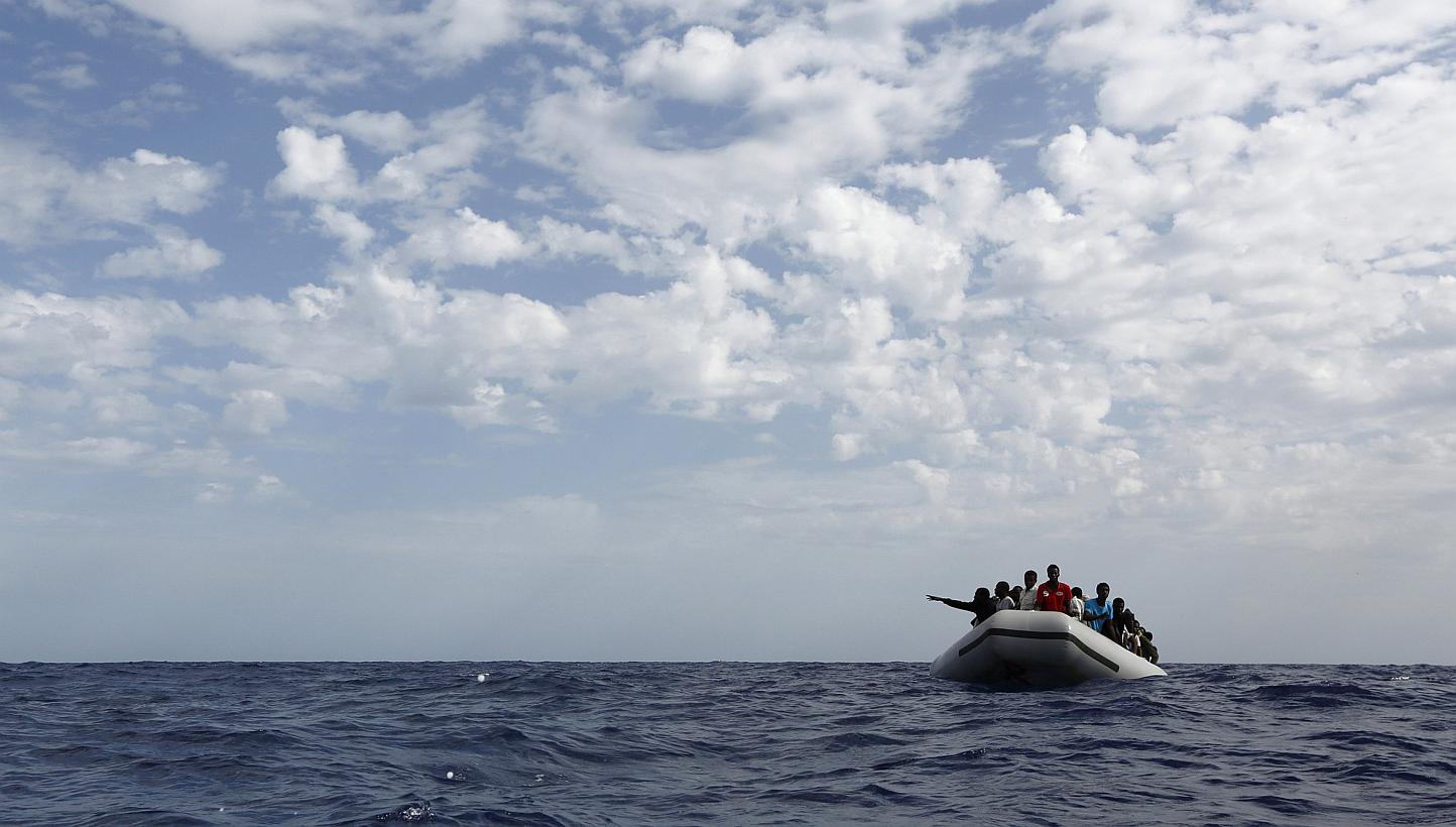 A group of 106 sub-Saharan Africans on board a rubber dinghy wait to be rescued by the NGO Migrant Offshore Aid Station some 25 miles off the Libyan coast, in this Oct 4, 2014 file photo. -- PHOTO: REUTERS