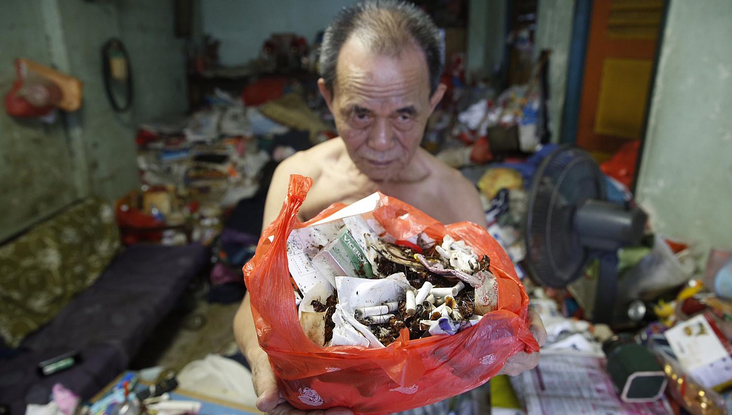 Mr Lim Chin Ting, 74, with a bag of cockroach remains and rubbish from his Eunos Crescent flat. His wife, Madam Soh Siew Zhen, has a compulsive hoarding habit, leading to a cluttered flat overrun by cockroaches and flies.