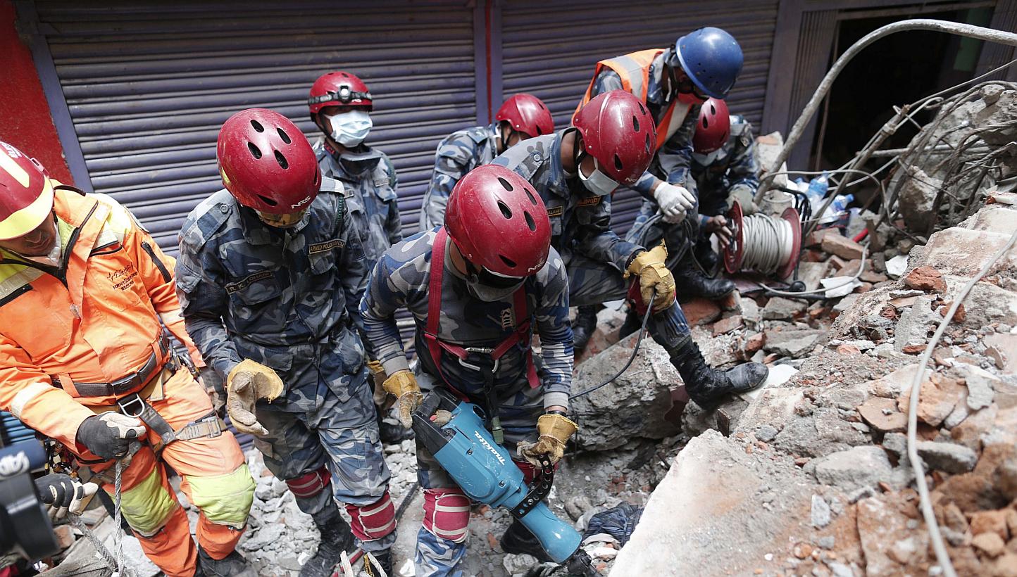 Members of a search and rescue team work in the rubble of a destroyed building in Kathmandu, Nepal, 01 May 2015. One thousand people from the European Union are missing in Nepal and 12 are confirmed dead, nearly a week after a devastating earthquake,