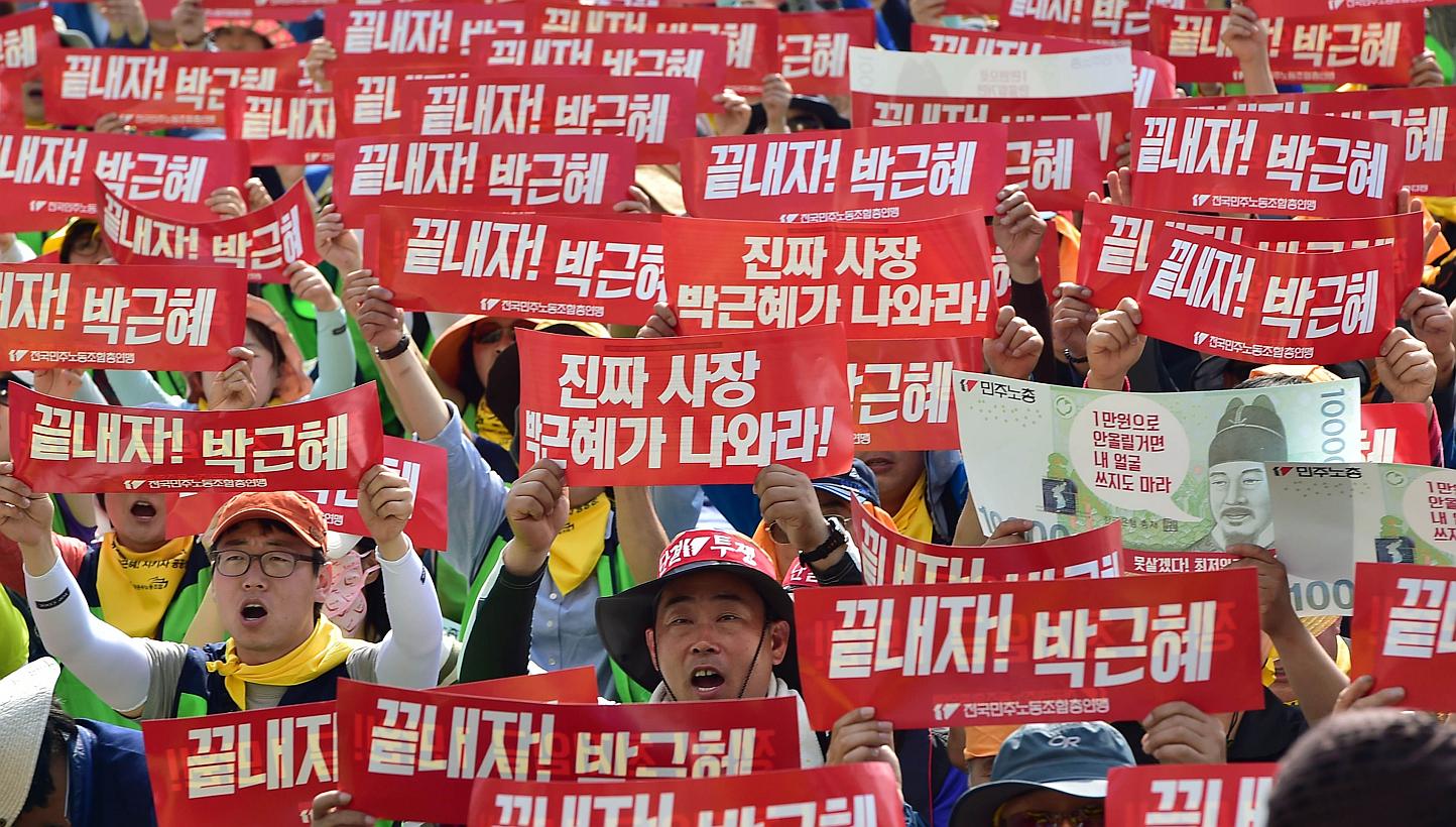 South Korean workers shout slogans with red banners reading Let's terminate Park Geun-Hye (government) during a May Day rally in Seoul on May 1, 2015. Tens of thousands of South Korean workers rallied in Seoul, vowing to wage an "all-out general stri