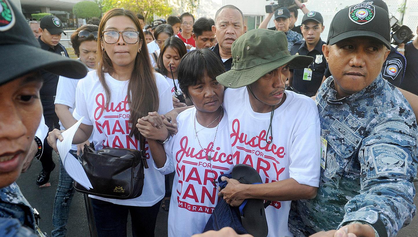 Celia Veloso (centre), the mother of Mary Jane Veloso, is escorted by a supporter upon her return from Jakarta in Manila on May 1, 2015. -- PHOTO: AFP