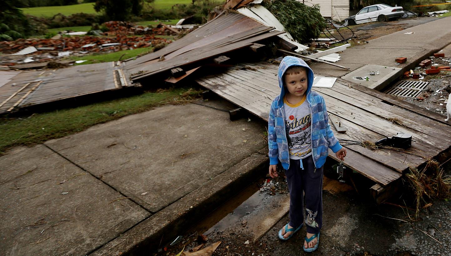 A young child amongst the damage and destruction caused by flooding in Dungog in the New South Wales, Hunter region, Australia on April 22, 2015. --PHOTO: EPA&nbsp;