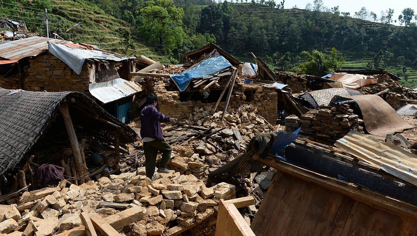 A Nepalese villager walks on the rubble of damaged homes in Baluwa, Gorkha District on May 1, 2015, following a 7.8 magnitude earthquake which struck the Himalayan nation on April 25, 2015. -- PHOTO: AFP