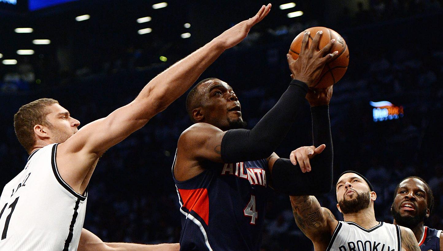 Atlanta Hawks' Paul Millsap (centre) drives to the basket past the Nets' Brook Lopez (left) and Deron Williams (right) during the first half of game six of the NBA playoff match at the Barclays Centre in Brooklyn, New York on May 1 2015. -- PHOT