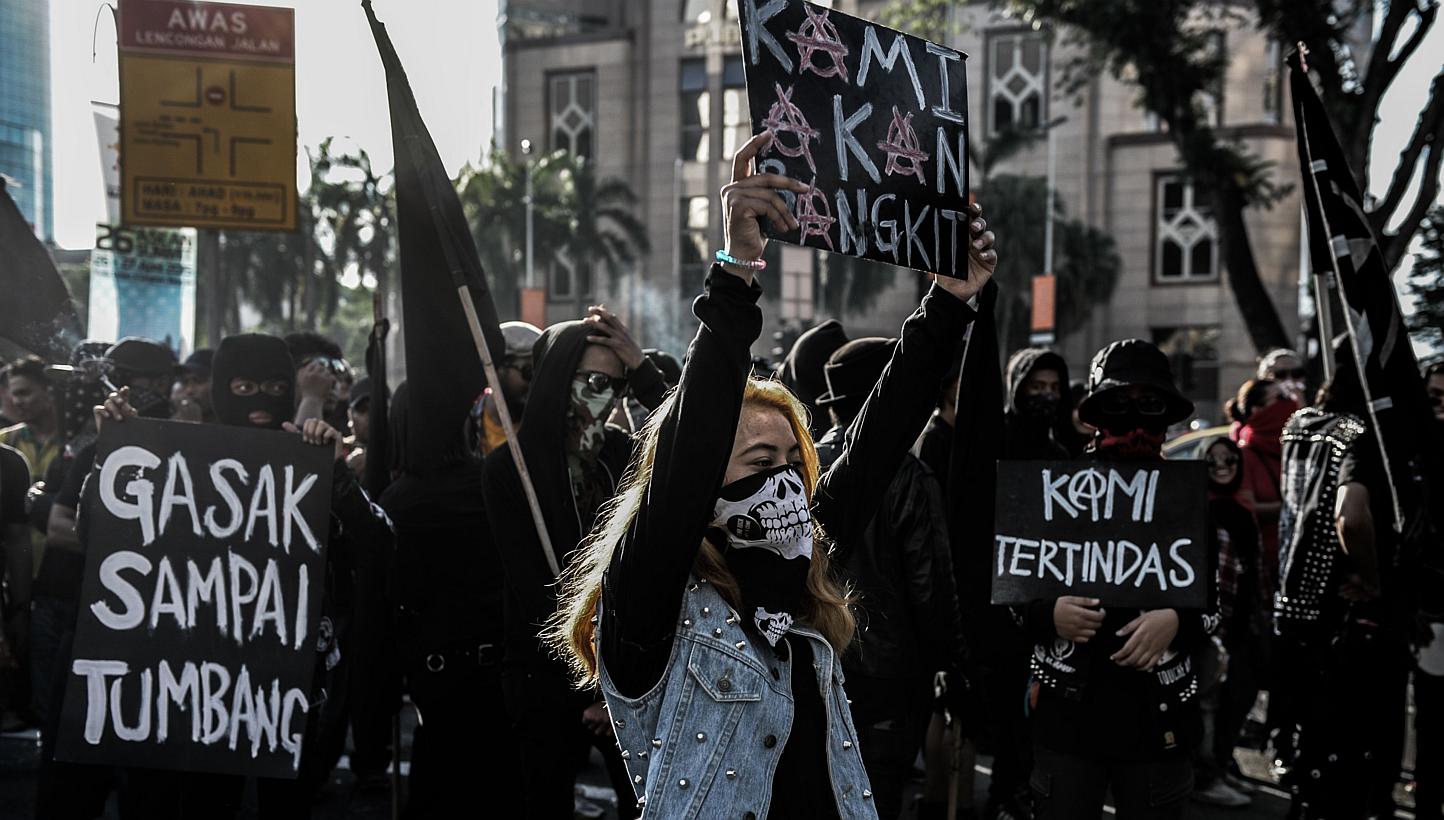 A Malaysian woman holding a placard reading "we will rise" in front of the Petronas Towers during a May Day protest against the GST in Kuala Lumpur on May 1, 2015. -- PHOTO: AFP