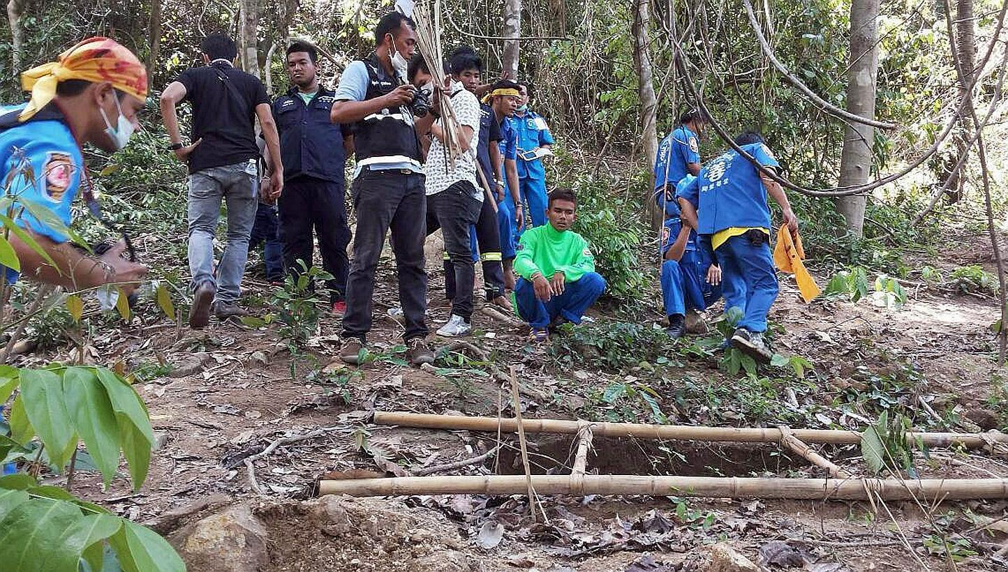 Rescue workers and forensic officials inspecting the site of a mass grave uncovered at an abandoned jungle camp in the Sadao district of Thailand's southern Songkhla province on May 1, 2015. -- PHOTO: AFP&nbsp;
